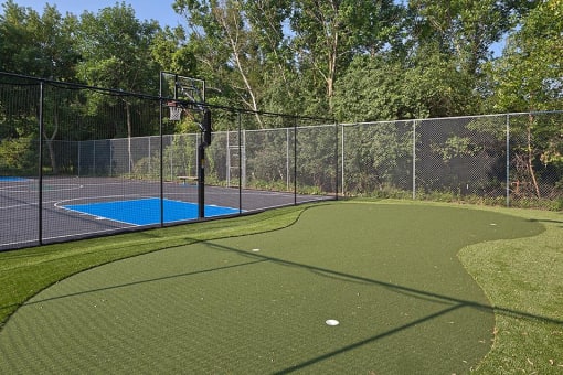 Outdoor recreation area with a putting green and basketball court