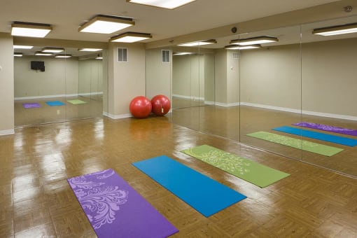Yoga studio with large mirrors, yoga mats, and exercise balls