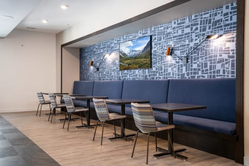 Banquette with blue cushions and a TV on the back wall