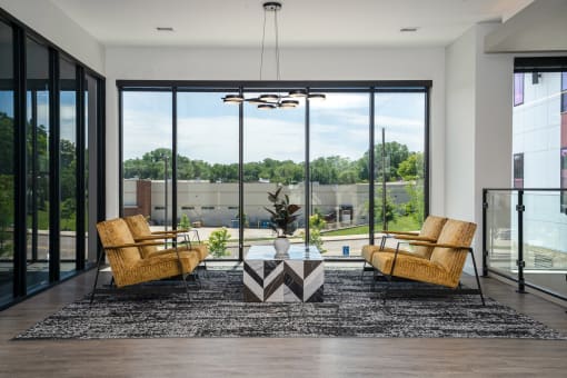 Lobby with chairs facing each other across a marble table and floor-to-ceiling windows