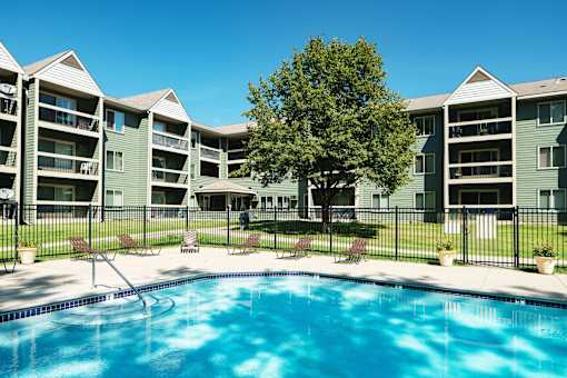 A swimming pool in front of apartment buildings.