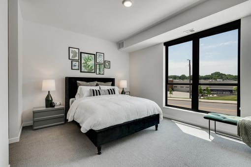 Bedroom with white walls, lamp shades, and comforters