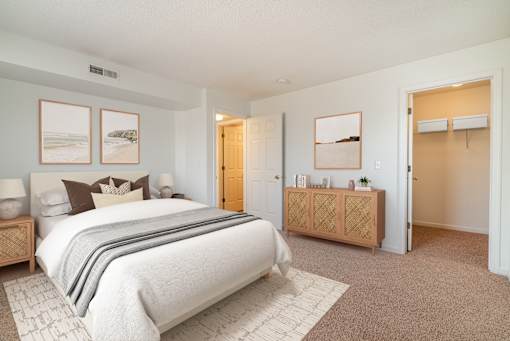 A bedroom with a large bed and a wooden cabinet.