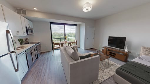 a living room and kitchen with a couch and a tv