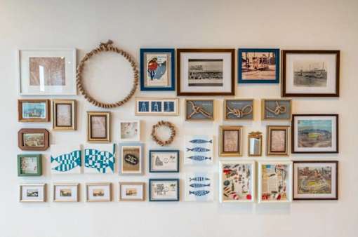 A wall filled with many different pictures and a wreath.