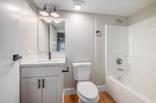 A white bathroom with a toilet, sink, and bathtub.