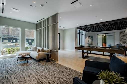 A living room with a black couch and a wooden table.