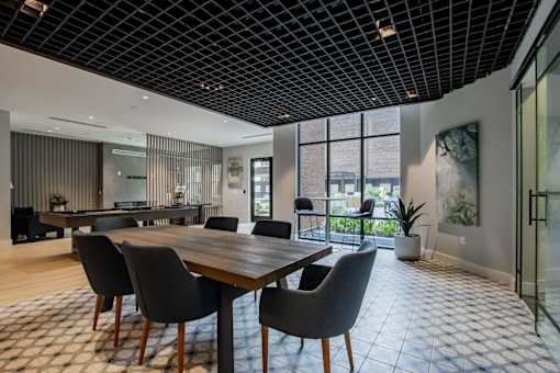 A modern dining room with a wooden table and chairs.