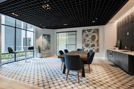 A modern dining room with a large table and chairs.