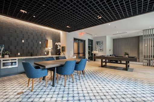 A dining room with a table and chairs.