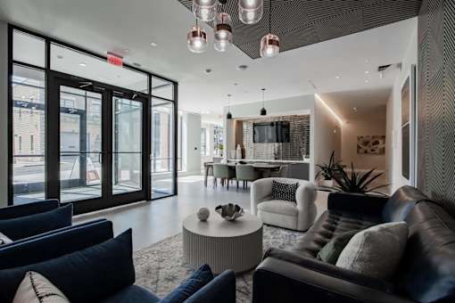 A modern living room with a black couch and a white coffee table.