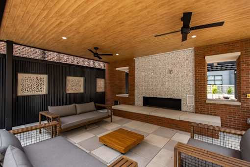A modern living room with a fireplace and a ceiling fan.