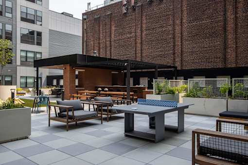 A patio with a table and chairs is surrounded by buildings.