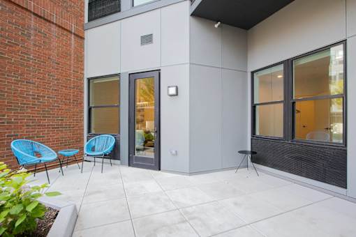A patio with a blue chair and a table.