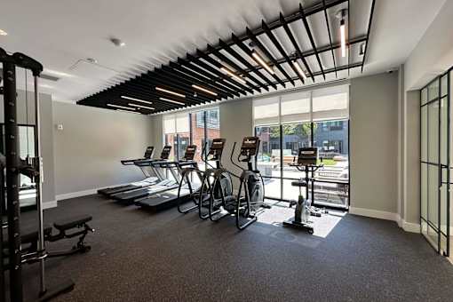A gym with treadmills, exercise bikes, and weights.