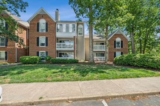 A row of houses with green lawns and trees at The Timbers Apartments, Richmond, VA, 23235