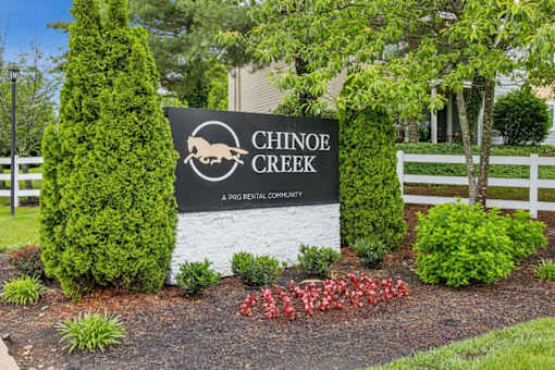 A sign for Chinook Creek in front of a white fence at Chinoe Creek Apartments, Kentucky, 40502