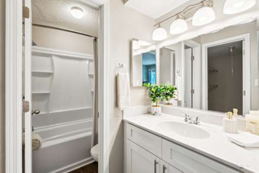 A white bathroom with a white sink and a white towel. at Woodcreek Apartments, North Carolina