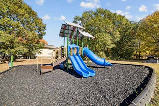 A playground with a blue slide and a green roofed structure at Lakecrest Apartments, PRG Real Estate Management, Greenville, SC, 29615