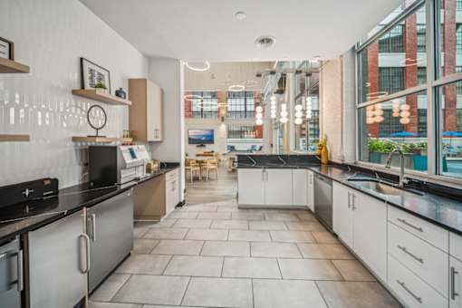 A modern kitchen with a black countertop and white cabinets. at The Locks, Richmond