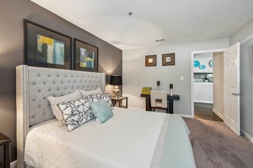 A bedroom with a large bed and a white headboard. at The Timbers Apartments, Richmond