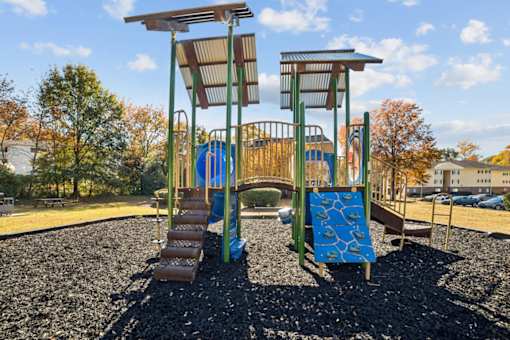 A playground with a blue slide and a brown wooden structure at Lakecrest Apartments, PRG Real Estate Management, Greenville, SC, 29615