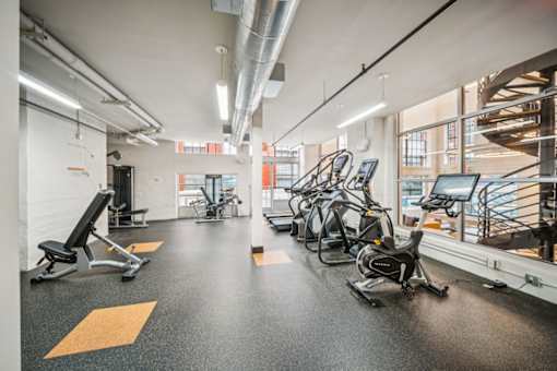 A gym with a variety of exercise equipment including treadmills, stationary bikes, and weight benches. at The Locks, Richmond, 23219
