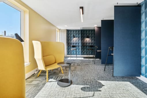 a lobby with yellow chairs and a blue and white rug  at The Box, Richmond, VA