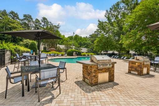 a backyard with a swimming pool and tables with umbrellas at Lake Johnson Mews, Raleigh, North Carolina