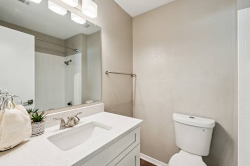 A white toilet sits next to a sink in a bathroom.