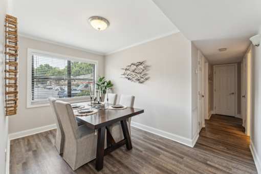 A dining room with a table and chairs.