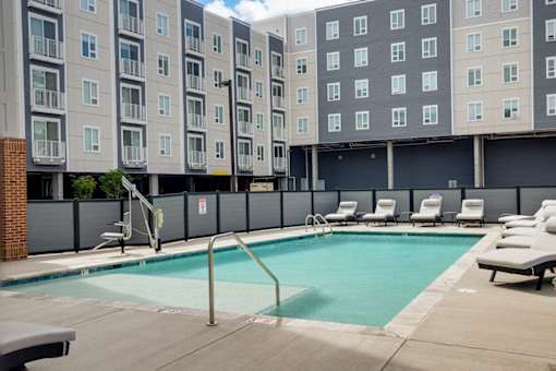 a swimming pool in front of a building at The Constellation Apartments, PRG Real Estate, Hampton, Virginia