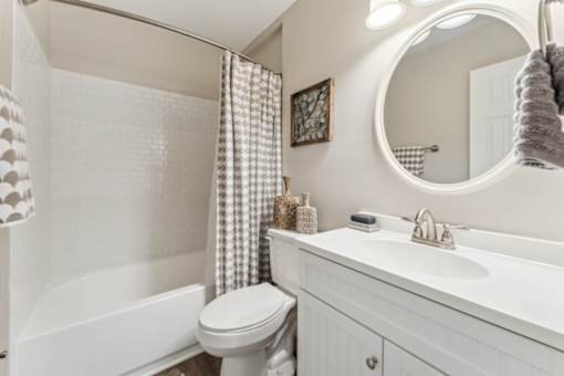 A white bathroom with a toilet, sink, and shower.