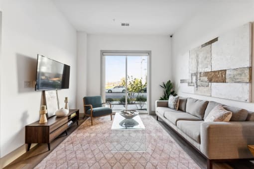 a living room with a large window, a couch, a chair, and a coffee table  at The Point on 38th, Norfolk