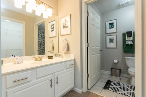 a bathroom with white cabinets and a white toilet at The Resort At Lake Crossing Apartments, PRG Real Estate, Lexington, KY