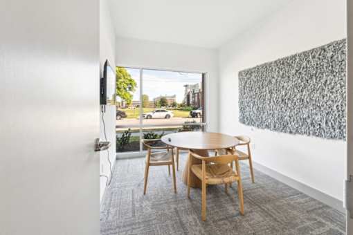 A room with a table and chairs and a painting on the wall at The Point Apartments on 38th, Norfolk, Virginia