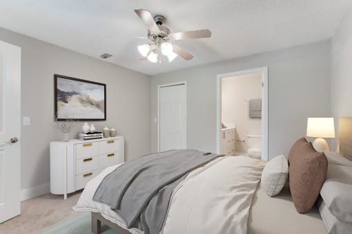 a bedroom with a bed and a ceiling fan at Palm Crossing Apartments in Winter Garden, FL