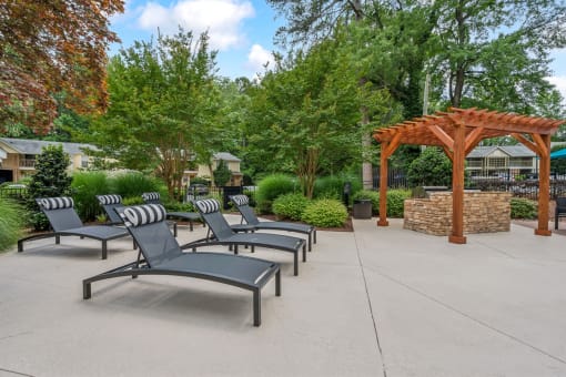 a group of lounge chairs sitting in front of a pavilion at Clarion Crossing Apartments, PRG Real Estate Management, Raleigh