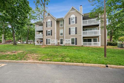 A large apartment building with a green lawn in front. at The Timbers Apartments, Richmond, VA