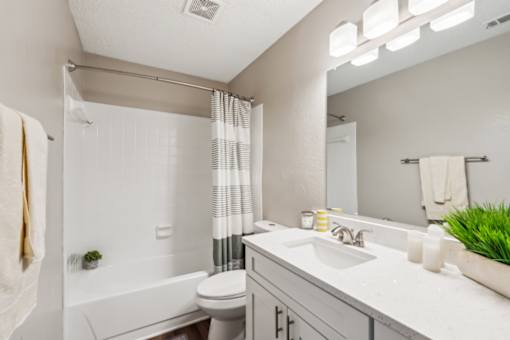 A white bathroom with a towel hanging on the wall.