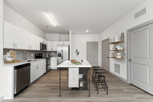 a kitchen with white cabinetry and a large white island with a white countertop at The Waterford At Rocketts Landing Apartments, PRG Real Estate, Richmond, Virginia