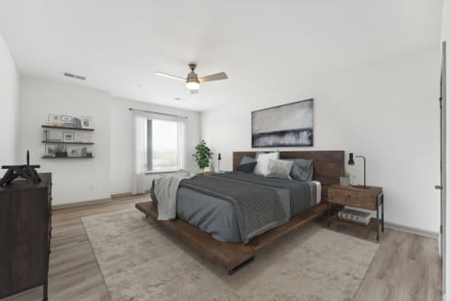 a bedroom with a large bed and white walls at The Waterford At Rocketts Landing Apartments, PRG Real Estate, Richmond, Virginia