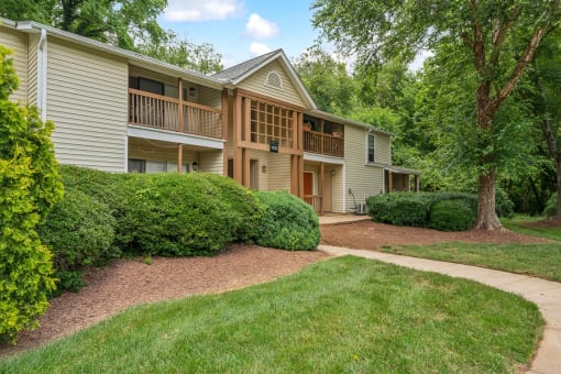 a walkway in front of a house with trees and grass at Clarion Crossing Apartments, PRG Real Estate Management, Raleigh
