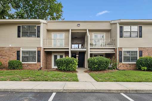 A two-story apartment building with a balcony on the second floor.