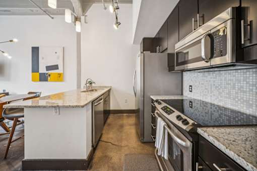 A modern kitchen with a white countertop and stainless steel appliances. at The Locks, Richmond, VA, 23219