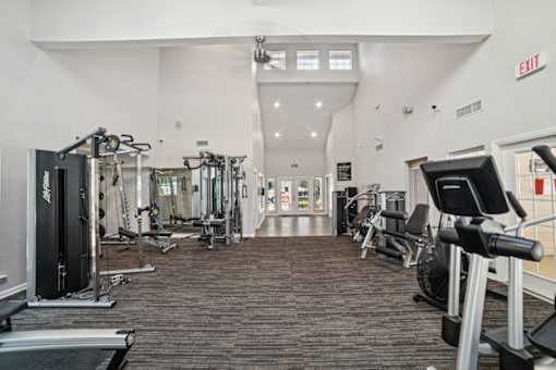 A gym with a variety of equipment including treadmills, weights, and exercise machines at Willow Ridge Apartments, North Carolina, 28210
