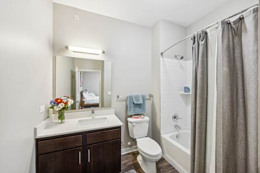 A bathroom with a sink, toilet, and shower. at AMP Apartments, Louisville