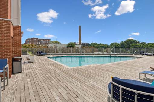 A wooden deck with a pool and a blue couch  at The Waterford At Rocketts Landing Apartments, PRG Real Estate, Richmond, Virginia