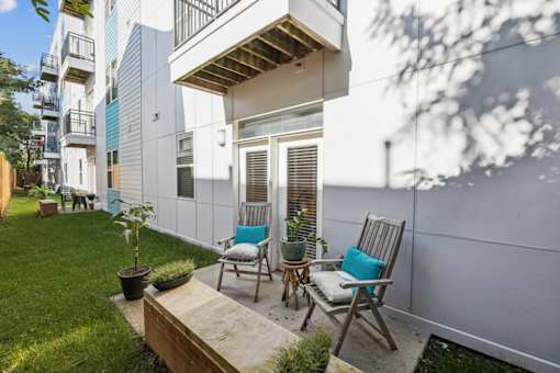 A small patio with two chairs and a table. at AMP Apartments, Kentucky