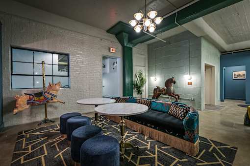 A room with a couch, chairs, and a table with a dog on a pole at The Carousel Apartments, Richmond, VA